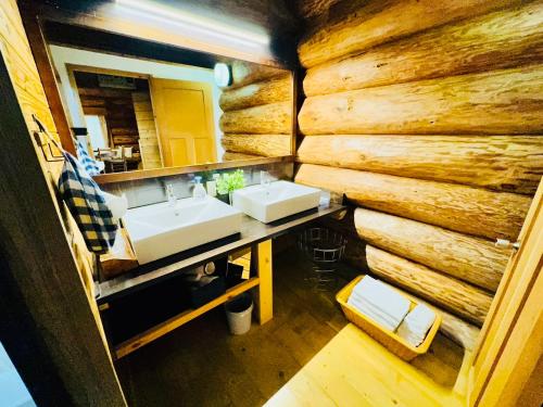由布市Yufuin Log House no Yado Tom Sawyer的一间带水槽和木墙的浴室