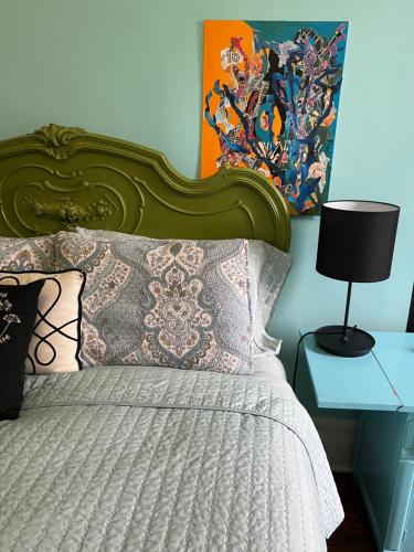纽约Soul Food的一张带绿色床头板的床和一张带台灯的桌子