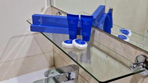 锡卜ALJAWHARA INN HOTEL的带牙刷的浴室内的玻璃架
