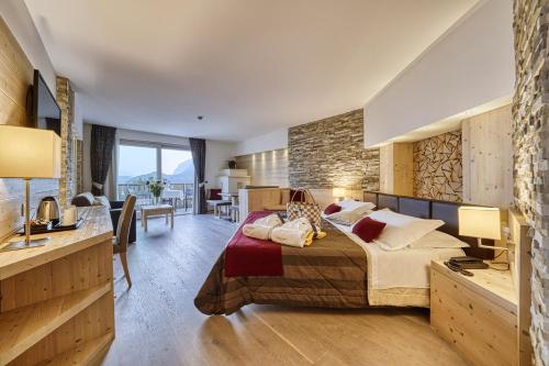 莫尔韦诺丽城阿尔卑斯山健康与美容度假酒店的一间卧室设有一张大床和石墙