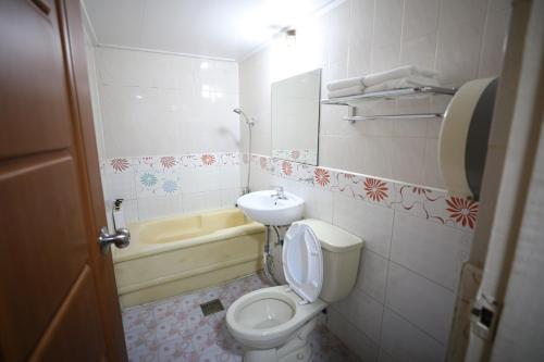 首尔Hotel Golden Hill的浴室配有卫生间、盥洗盆和浴缸。