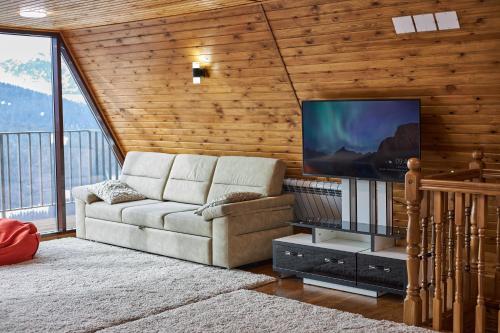 卡拉科尔Karakol Resort的带沙发和平面电视的客厅