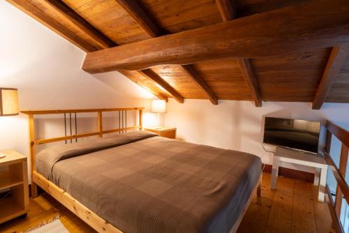 萨尔扎纳Agriturismo Il Monticello的一间卧室配有一张床和一台平面电视