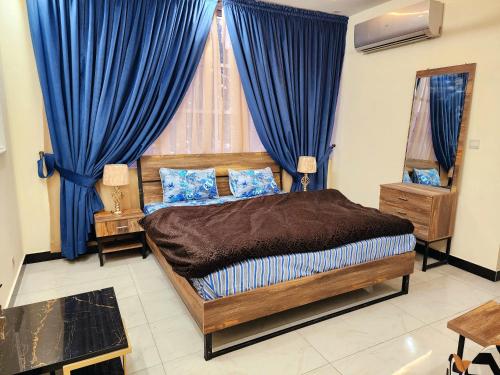 伊斯兰堡Motorway Majesty Lodges - Near Islamabad International Airport & Motorway的一间卧室配有一张带蓝色窗帘的大床