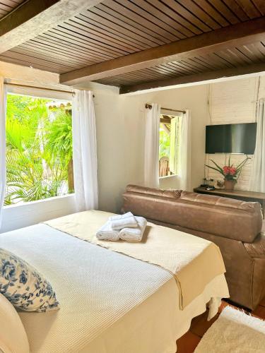 塞古罗港Chales do Oliveira的一间卧室配有一张床、一张沙发和一个窗口