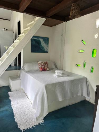 塞古罗港Chales do Oliveira的卧室设有白色的床和楼梯