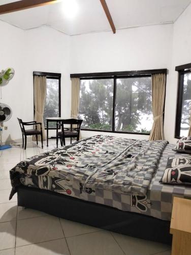 茂物Villa sagitarius的卧室配有床、桌子和窗户。