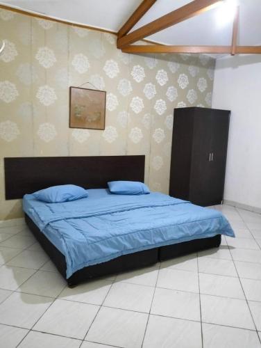 茂物Villa sagitarius的一间卧室配有一张带蓝色棉被的床