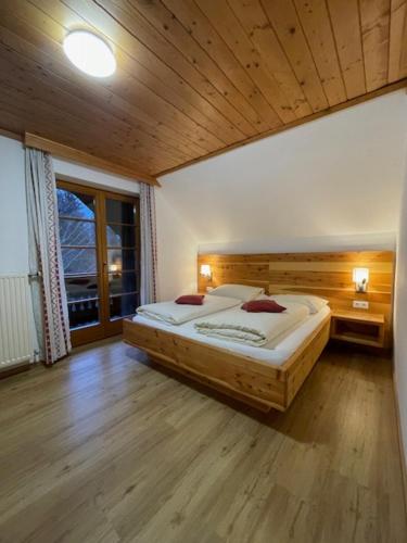 滨湖费尔德图尔奈霍夫宾馆的一间卧室设有一张大床和木制天花板