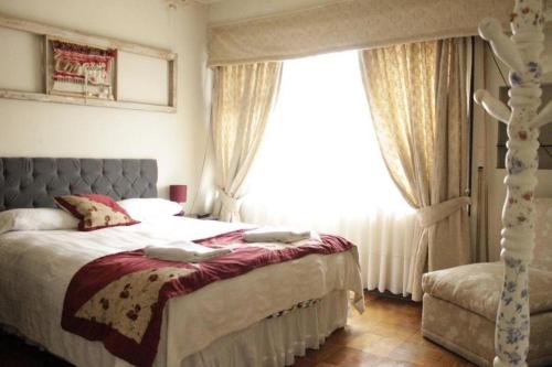 塔尔卡Oriente Hostal的一间卧室设有一张床和一个大窗户