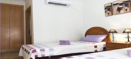 佩德雷尔Appartement Mar y golf的配有紫色和白色床单的客房内的两张床