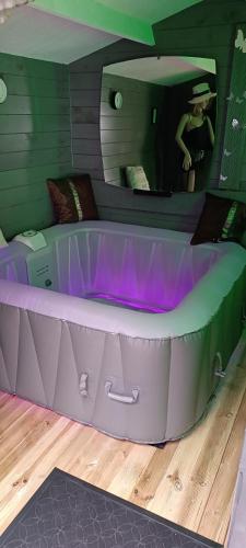 安德诺莱斯贝恩LOVE ROOM Cabane des charmes的客房内的浴缸配有紫色灯