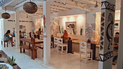 南圣胡安Casa Oro Eco Hostel的一间餐厅,人们坐在房间里桌子旁