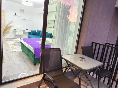 布拉索夫Coresi Mall Area Studios & Apartments by GLAM的配有一张床和一张桌子及椅子的房间
