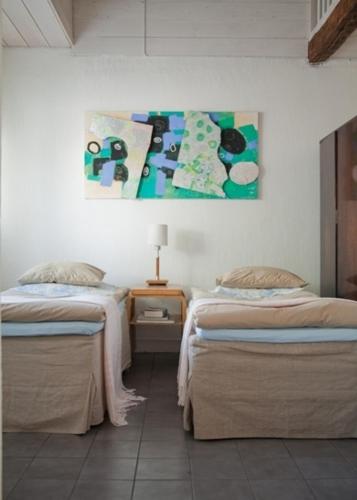埃克奈斯Alapiha Apartments的一间卧室设有两张床,墙上挂着一幅画
