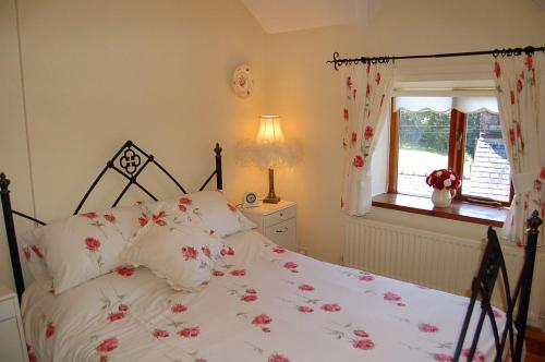 多尔盖罗Tre-Allt Gorgeous Cottage的一间卧室,床上有粉红色的鲜花