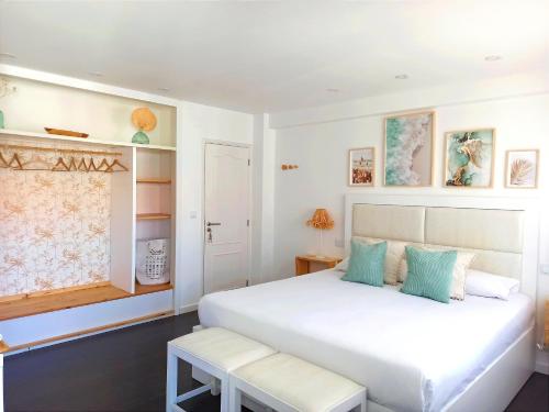 佩尼契SUPERTUBOS HOUSE Peniche的卧室配有白色的床和长凳
