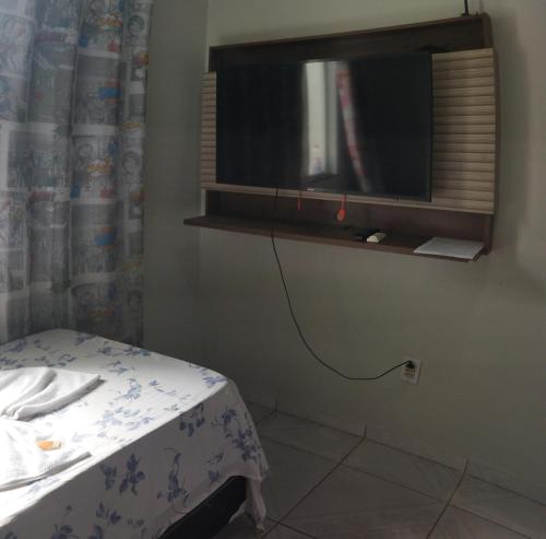 博阿维斯塔Apartamento Central Privativo的一间房间,配有一张床和墙上的电视