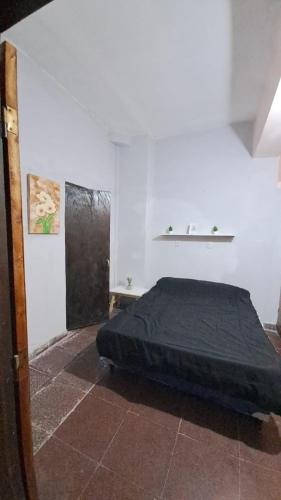 卡塔马卡Delfina -Catamarca, Zona Centro的卧室位于客房的角落,配有一张床