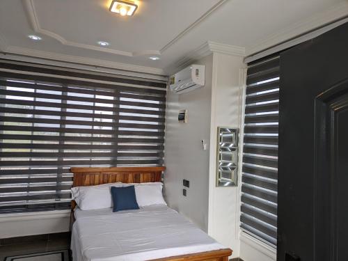 PrampramKabeya Place的一间卧室配有一张床和一个带百叶窗的窗户