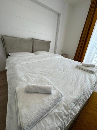 特尔古穆列什LUNA Apartments B18的一张白色的床,上面有两条毛巾