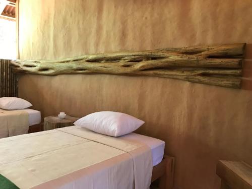马尔多纳多港Casa Amazonas的一间设有两张床的客房,墙上挂着一幅画