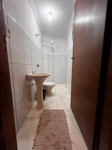 阿帕雷西达Hotel Cesar Nogueira的白色的浴室设有水槽和卫生间。