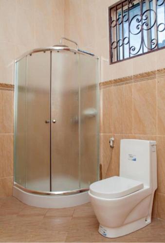 南威Taj hotel partnership的一间带玻璃淋浴和卫生间的浴室
