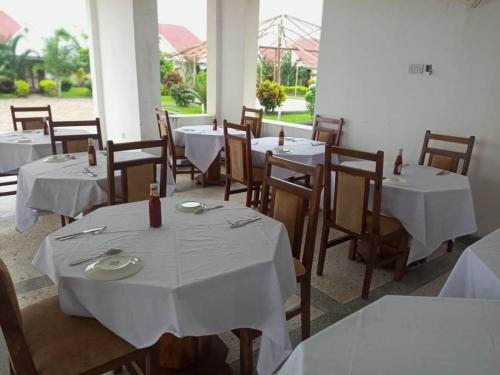 南威Taj hotel partnership的餐厅配有桌椅和白色的桌布