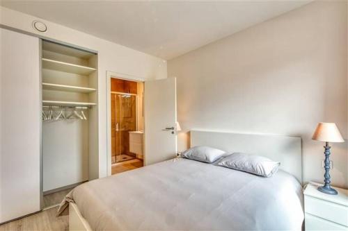 列日Splendide appartement au centre de Liège - Complexe PARADIS EXPRESS的白色卧室设有一张大床和一个衣柜