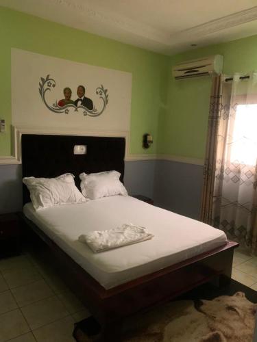杜阿拉Résidence Longchamp的一间卧室配有一张带白色床单的大床