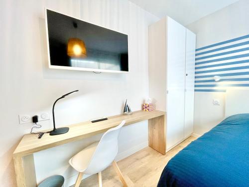洛里昂A L'ABORDAGE APPART - Lorient centre - Au calme的一间卧室配有书桌、一张床、一张床和一把椅子