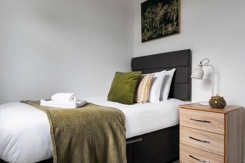 科尔切斯特Sunbeam cottage contractor Parking WiFi Garden的一间卧室配有一张带白色床单的床和床头柜。