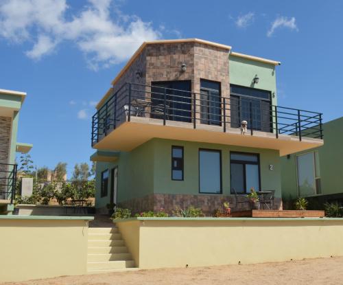 恩塞纳达港Casa Berty 4的海滩上的房子,阳台上有狗