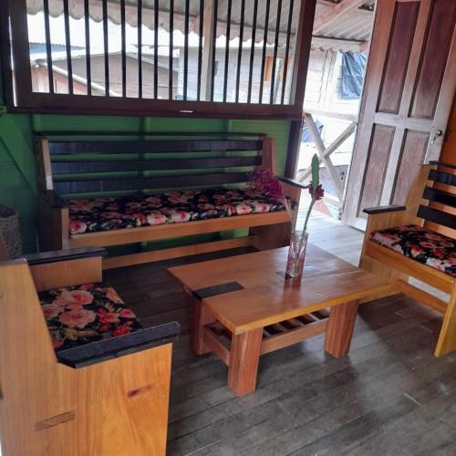 JuruvidáPosada jurubira的一间设有两张床、一张桌子和一张长凳的房间