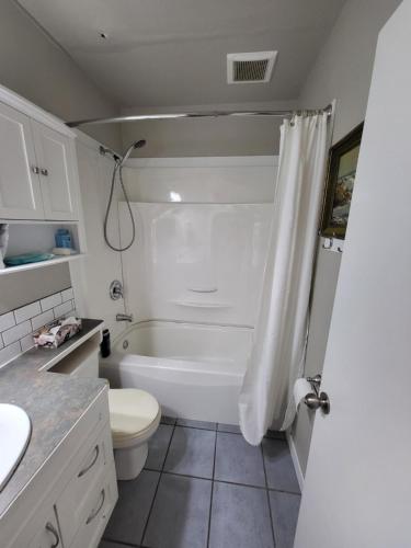 埃德蒙顿A Place to Call Home的浴室配有白色浴缸和卫生间。