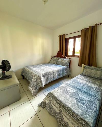 巴纳内拉斯Casa em Bananeiras PB的一间卧室设有两张床和窗户。