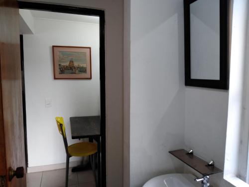 波哥大Hostal Norma101的浴室设有镜子、水槽和椅子