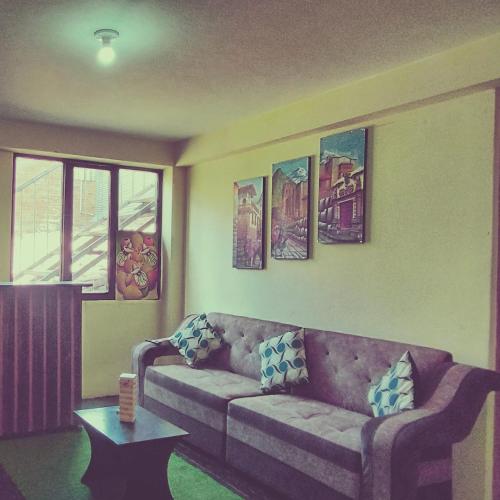 库斯科MEDIA LUNA apart的客厅配有沙发和墙上的绘画