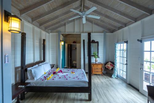 Crab HillThe Ti-Kaye Oasis的一间卧室配有一张带吊扇的床
