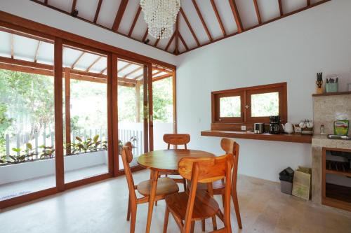 龙目岛库塔Karyana Apartment的一间带桌椅和窗户的用餐室