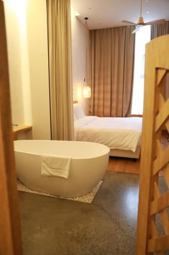 上海上海浦东机场幔麓酒店·宠物友好的带浴缸的浴室和1间带1张床的卧室