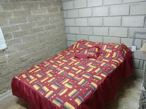 Pueblo NuevoLas escondidas的床上有五颜六色的毯子