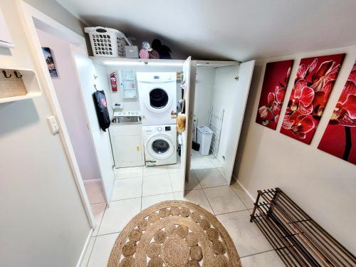 派西亚Unique Estuary & Bird Apartment in Te Haumi Paihia的小型洗衣房配有洗衣机和烘干机