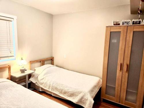 萨尼亚Bluewater Delight的一间卧室设有两张单人床和一个橱柜