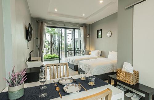 Bang HiaThe River Palm Resort的酒店客房设有两张床和一张带盘子的桌子。