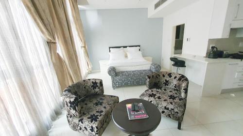 哈博罗内iTowers Studio-Suite的客厅配有两把椅子、一张桌子和一张床