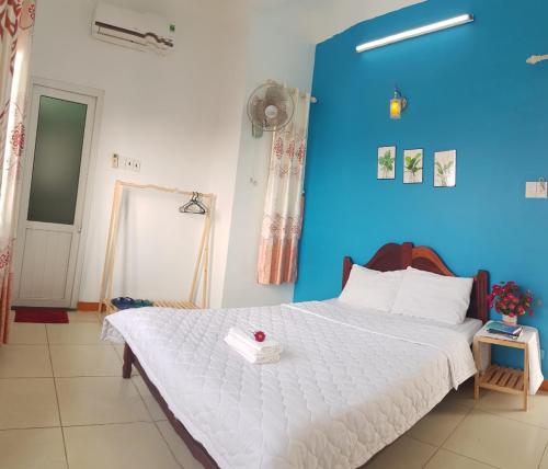 惹岛Ly Tri Ly Son Hotel的一间卧室配有一张白色大床和蓝色的墙壁