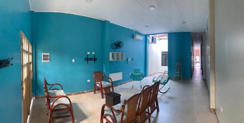 伊基托斯Casa Bolognesi的一间设有蓝色墙壁、椅子和桌子的客房