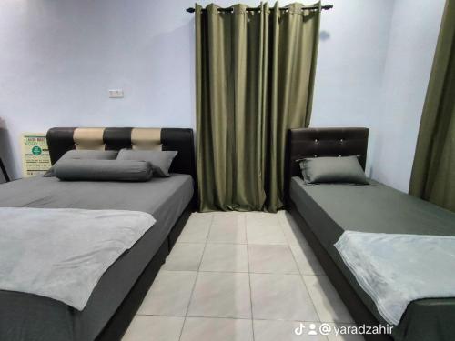 Kepala BatasHomestay HABI Residence的绿窗帘间内的两张床
